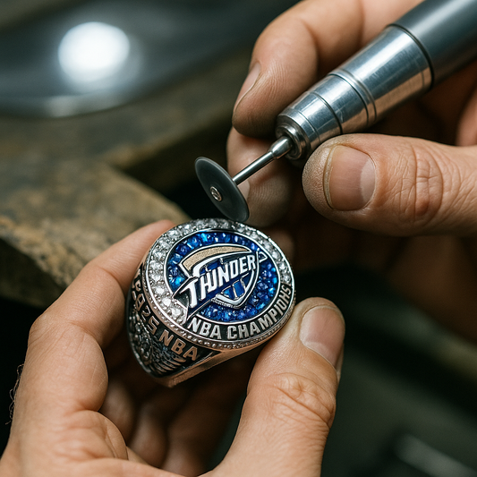 Jeweler crafting the Oklahoma City Thunder 2025 Championship Ring, showing blue sapphires being set into silver metal under bright studio lighting — a behind-the-scenes look before the replica release at GameDayRings.com.